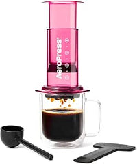 AeroPress Clear Rosa: Cafetera 3 en 1 que combina prensa francesa, espresso y café con cuerpo sin posos ni amargor; pequeña, portátil, ideal para camping y viajes, en color rosa.